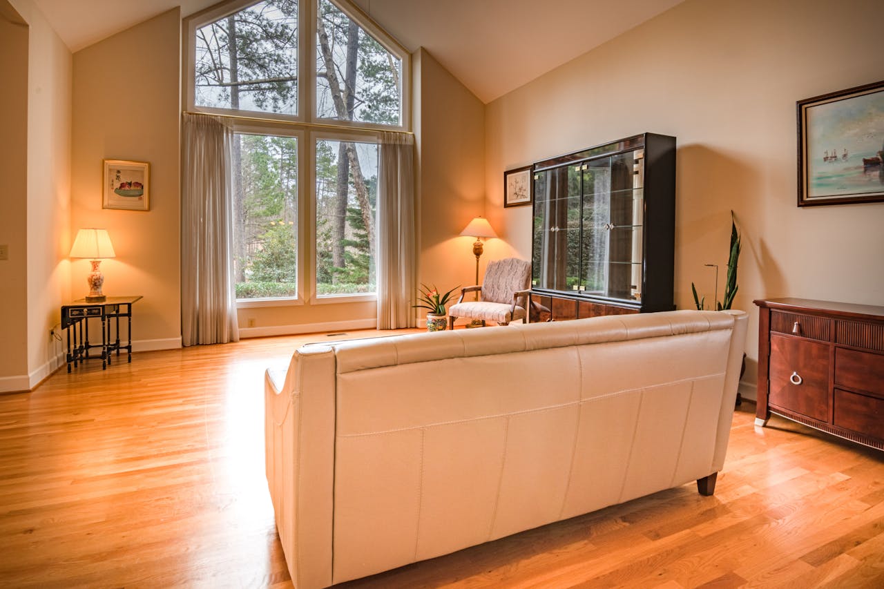 Inviting living room featuring large windows, modern decor, and wooden flooring, perfect for relaxation.